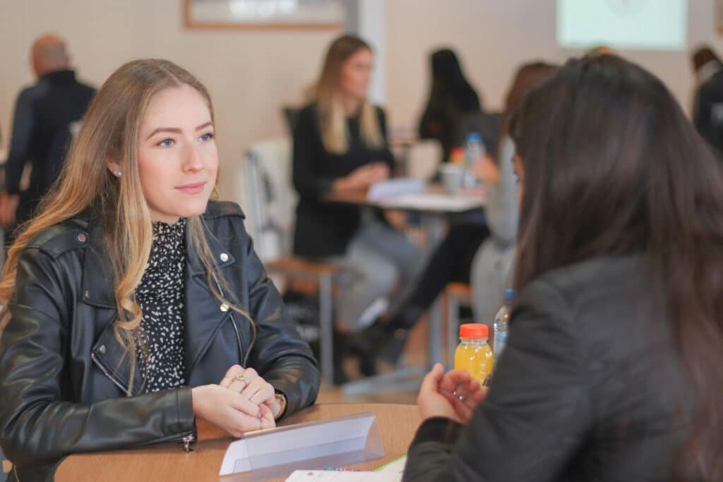 Une jeune femme blonde souriante participe à un entretien de job dating